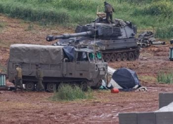 দক্ষিণ লেবাননের সীমান্তের কাছে  একজন ইসরায়েলি সেনা একটি স্বচালিত হাউইটজার কামানের ওপর দাঁড়িয়ে আছে।