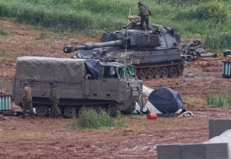 দক্ষিণ লেবাননের সীমান্তের কাছে একজন ইসরায়েলি সেনা একটি স্বচালিত হাউইটজার কামানের ওপর দাঁড়িয়ে আছে।